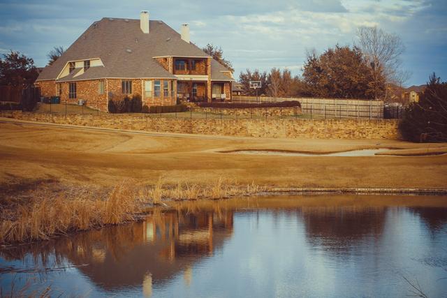 Brick home on a rise above a pond