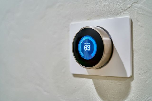 Digital wall thermostat mounted in a hallway