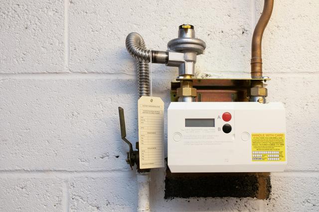 Gas meter and regulator mounted on a block wall