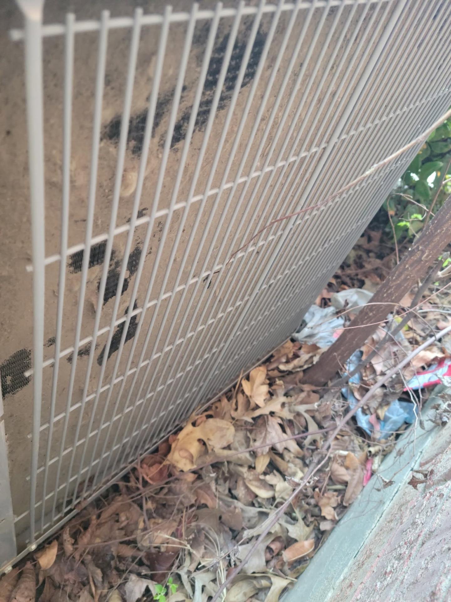 Outdoor condenser coil packed with leaves and yard debris, found on an HMS service call