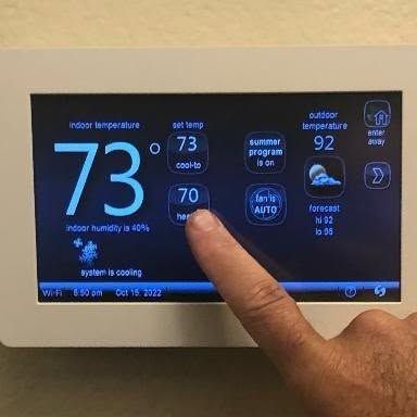 Smart thermostat touchscreen set to 73 degrees with the system running in cooling