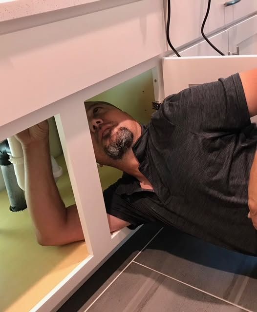 HMS technician reaching inside an opened unit cabinet to inspect it