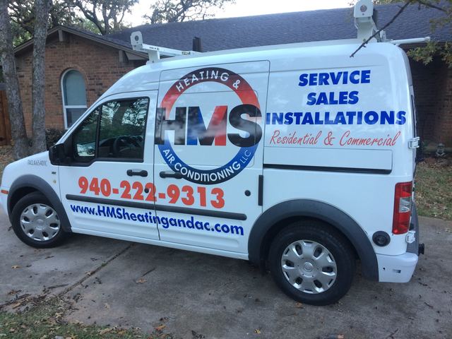 HMS service van parked in the driveway of a brick home
