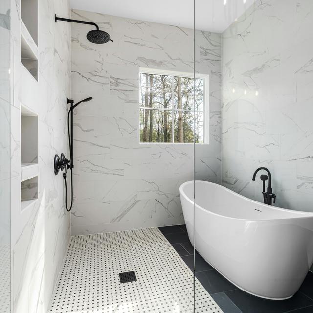 Remodeled bathroom with a freestanding tub, walk-in glass shower, and black fixtures
