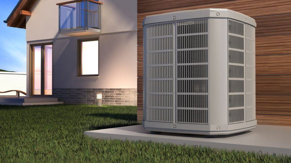 Outdoor air conditioning condenser on a concrete pad beside a modern home