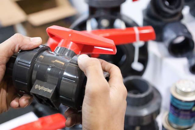 Hands turning the lever on a PVC ball valve