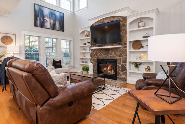 Living room with leather chairs and a lit stone fireplace